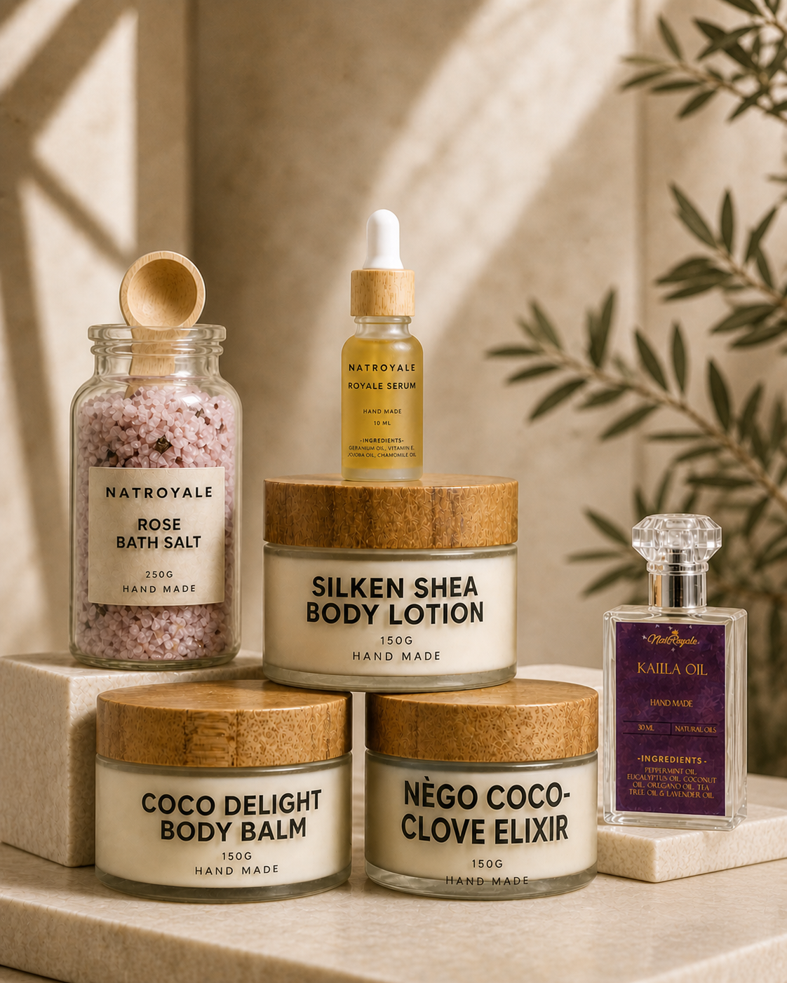 The Natroyale Ritual Set — Silken Shea Body Lotion, Coco Delight Body Balm, Royale Serum, Rose Bath Salt and Kalila Oil styled together on a stone surface with olive leaves — luxury natural bodycare gift bundle handmade in the UK.